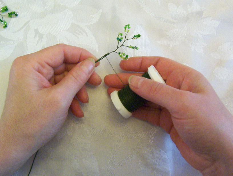 7.Prendre une tige de fil à grillage d'environ 20 cm.  Commencer à enrouler une feuille sur la tige avec le fil à lier.
